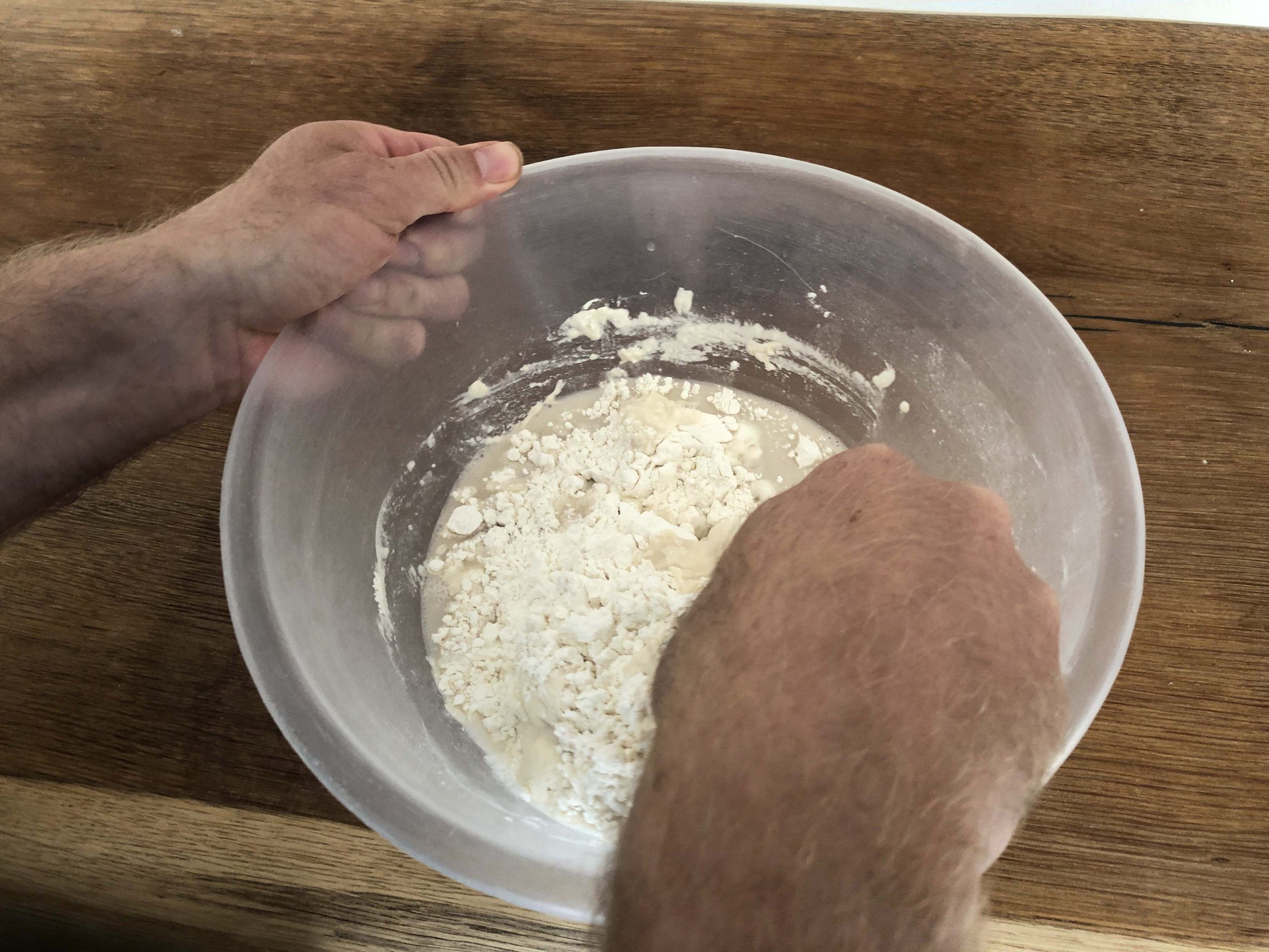 Move both hands in opposite directions with the scraper in the right hand here mixing the ingredients